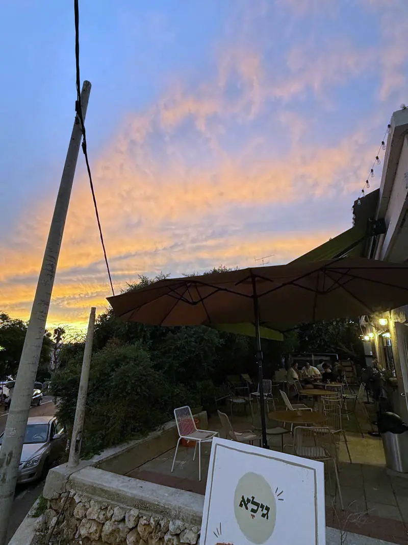 שקיעה כתומה מעל המרפסת, שלט גילא בכניסה